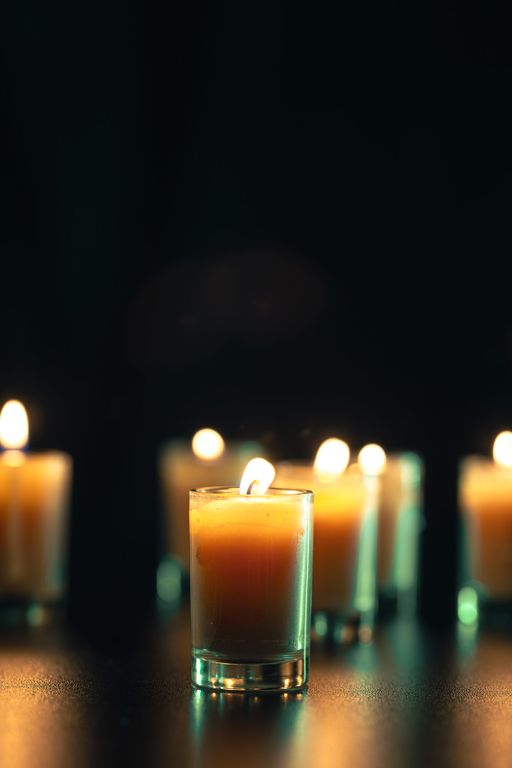 burning candle on black background with backlight. memorial day.